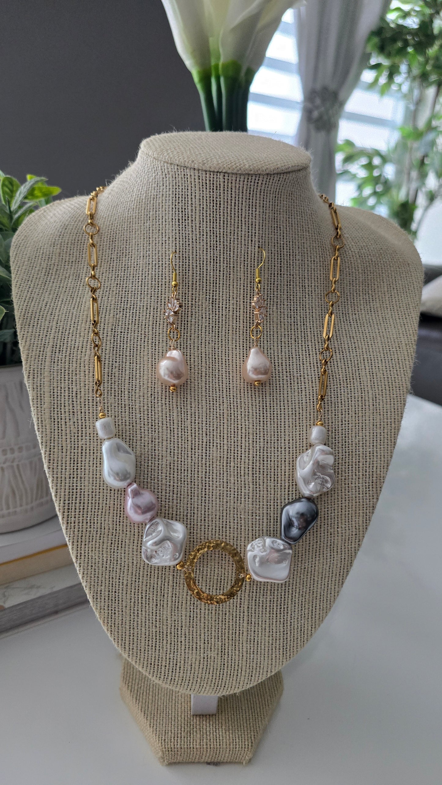 Cabeza de maniquí con exhibición de joyas que incluye collares y pendientes de color plata y blanco.