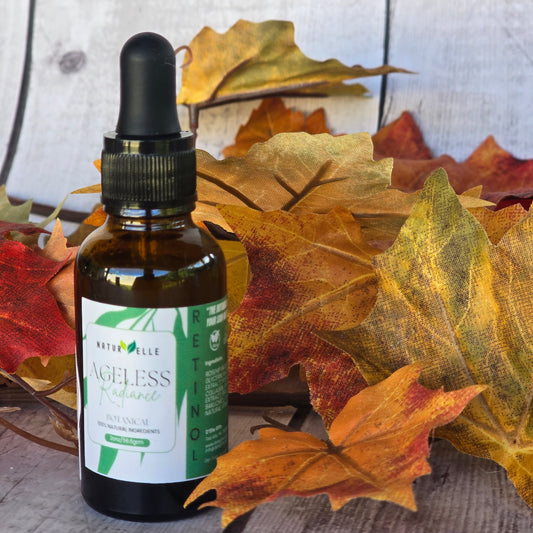 Frasco del producto para el cuidado de la piel 'Ageless' sobre una superficie con hojas de otoño — NaturElle Puerto Rico