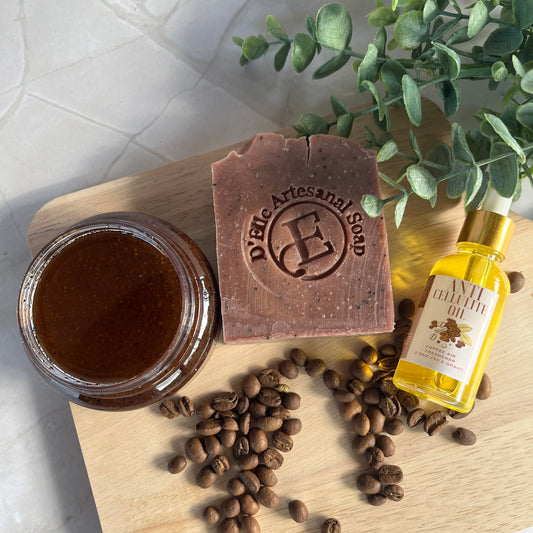 Bar of soap, jar, bottle, and coffee beans on a wooden board with a plant in the background.