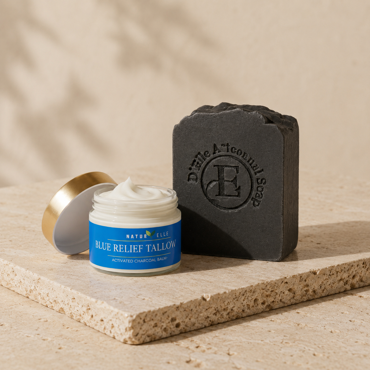 Bálsamo de sebo Blue Relief y barra de jabón negro sobre una superficie de piedra con fondo beige — NaturElle Puerto Rico