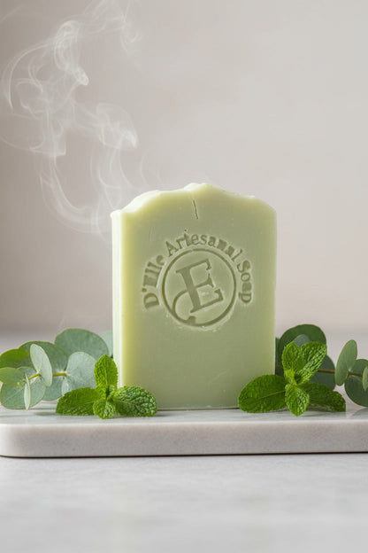 Pastilla de jabón verde con vapor ascendente, rodeada de hojas verdes sobre una superficie blanca — NaturElle Puerto Rico
