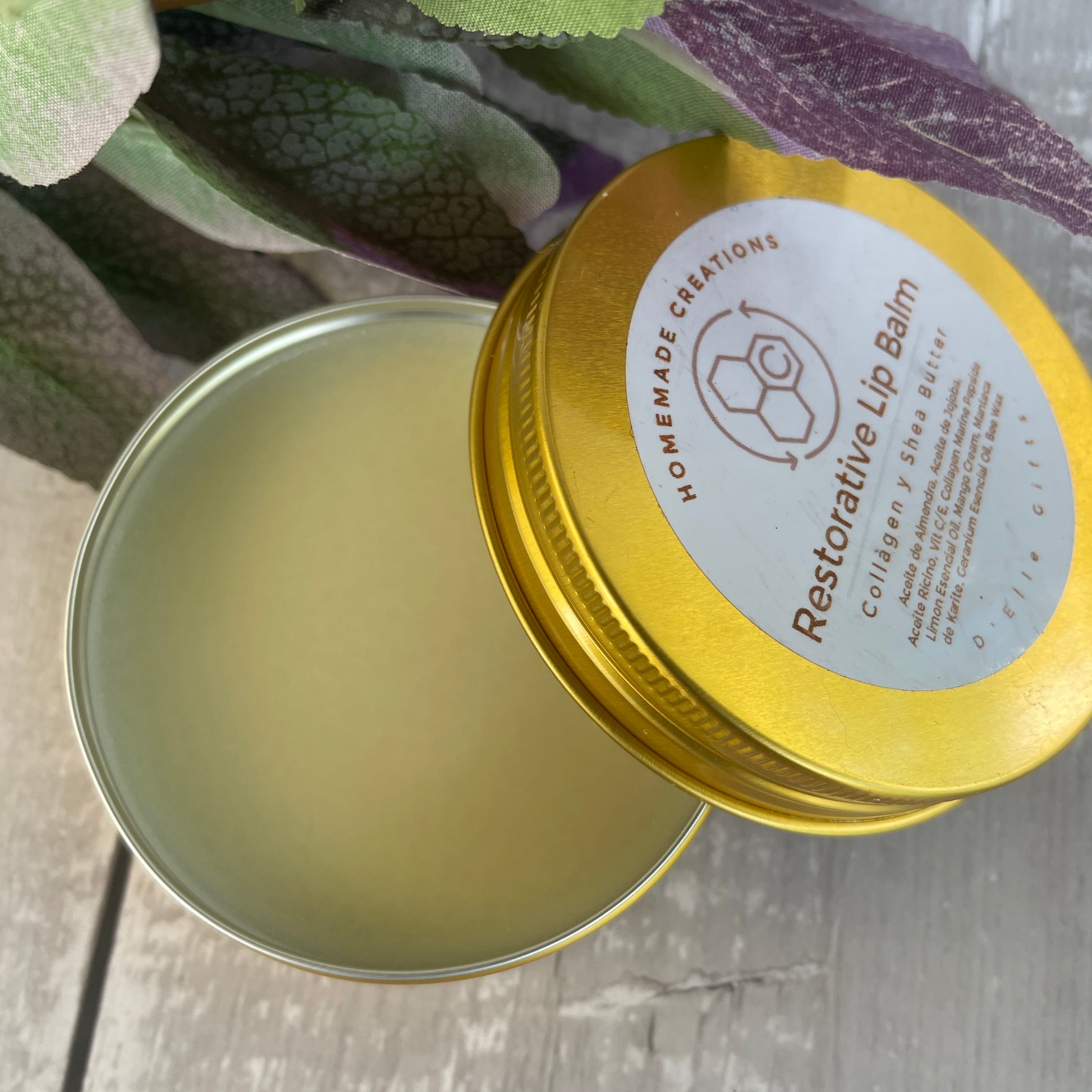 Un envase de hojalata color dorado de Intensive Repair Lip Balm, sin tapa, que deja ver el bálsamo en su interior. La etiqueta de la tapa dice "Intensive Repair Lip Balm" e incluye una ilustración de una abeja y algunos detalles adicionales del producto. — NaturElle Puerto Rico